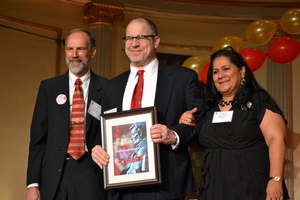 Two men and a woman accepting an award
