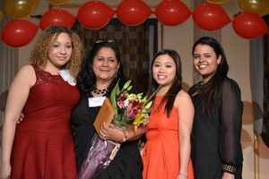Woman and three female students holding flowers
