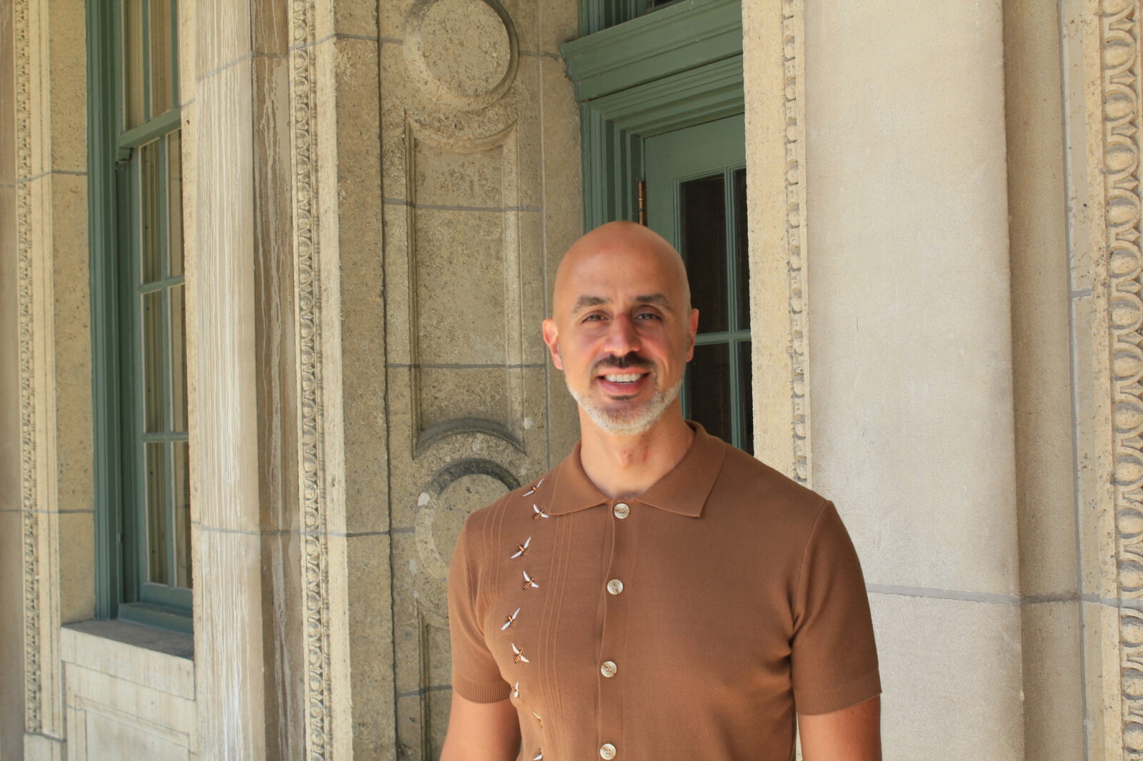 Bio picture of CeO Alumni, Joe Maldonado, wearing a cider colored button-up polo shirt in front of a brick structure.